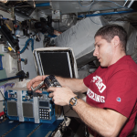 Astronaut Mike Hopkins operating one of the GAPs containing the AES-1 experiment onboard ISS (Photo credit: NASA).